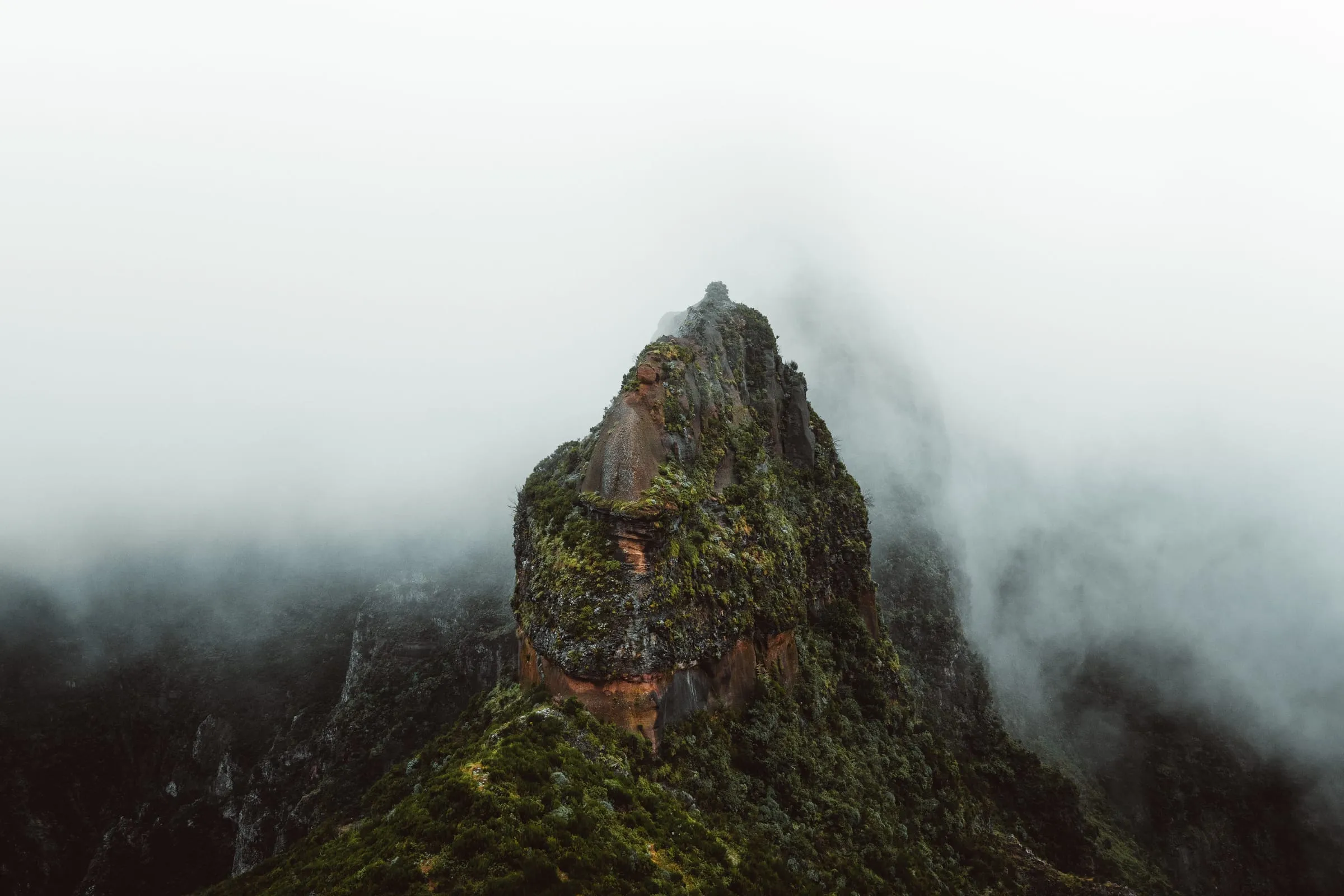 Skalní vrchol zahalený mlhou na treku z Pico do Arieiro na Pico Ruivo