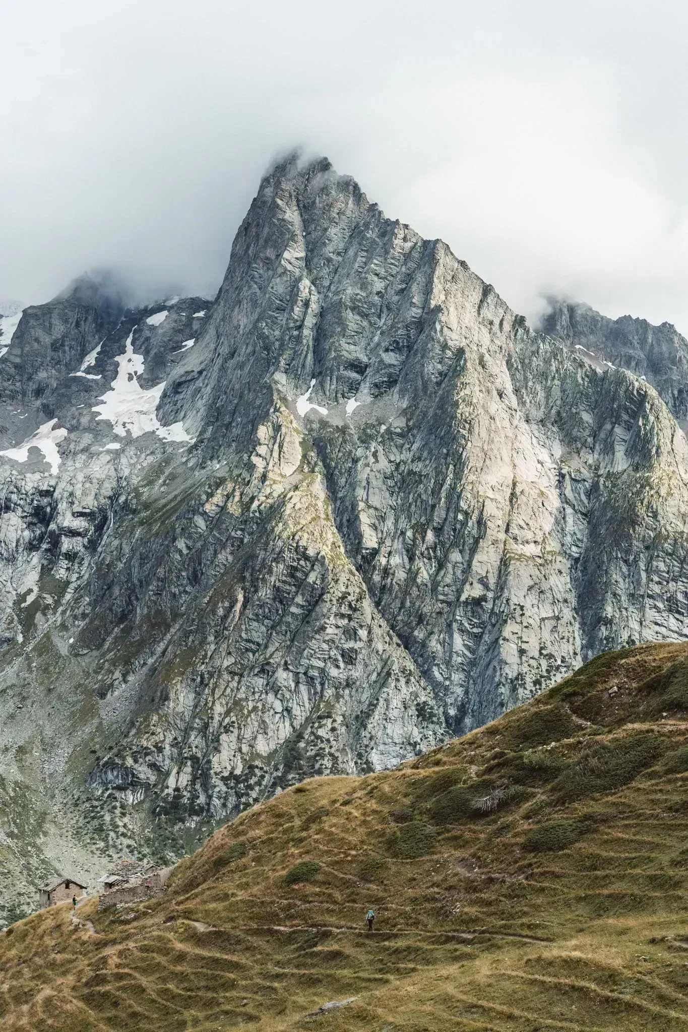 Strmý skalní štít nad zeleným svahem