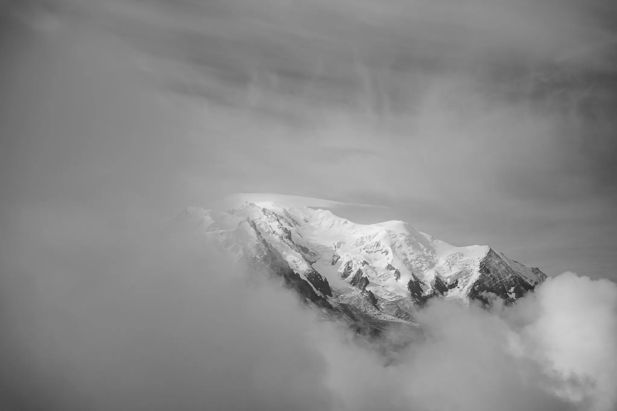 Mont Blanc vystupující z mraků, černobílá fotografie