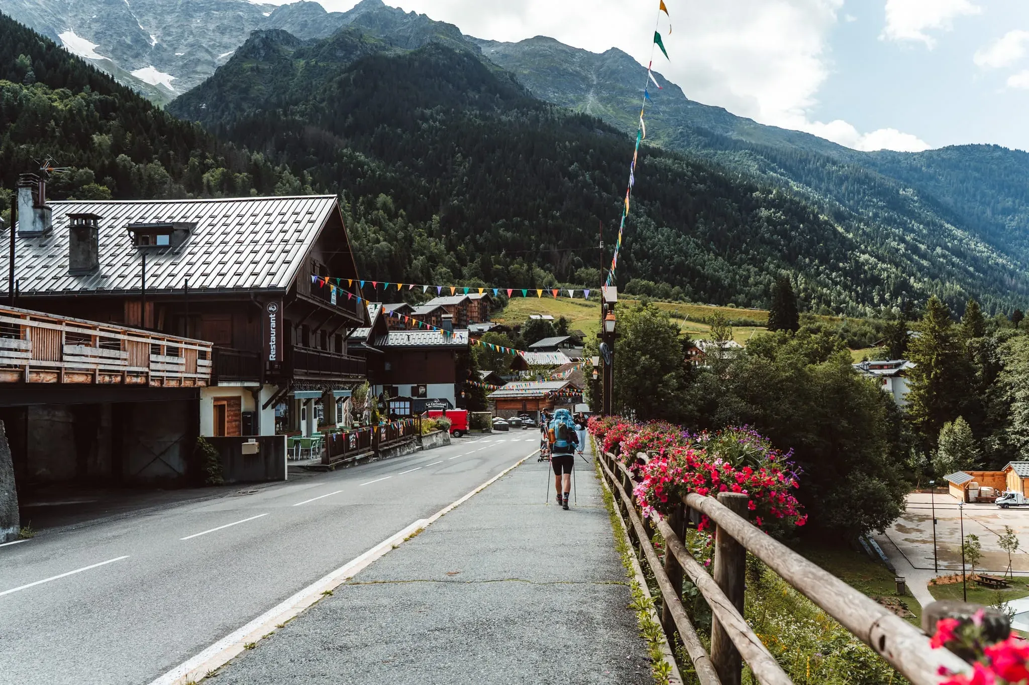 Trekař na chodníku podél silnice v Les Contamines