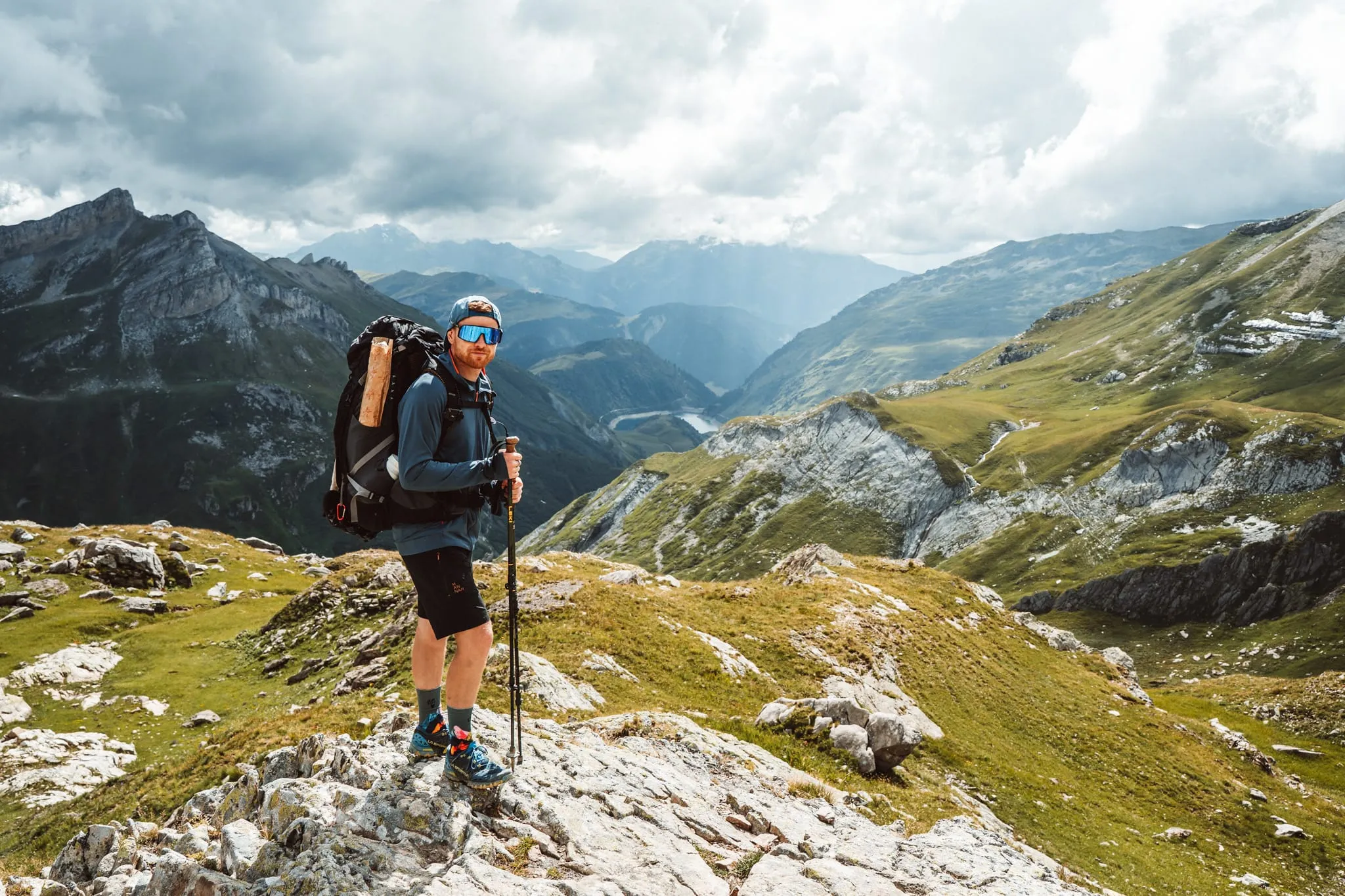 Trekařka na skalách s výhledem do alpského údolí